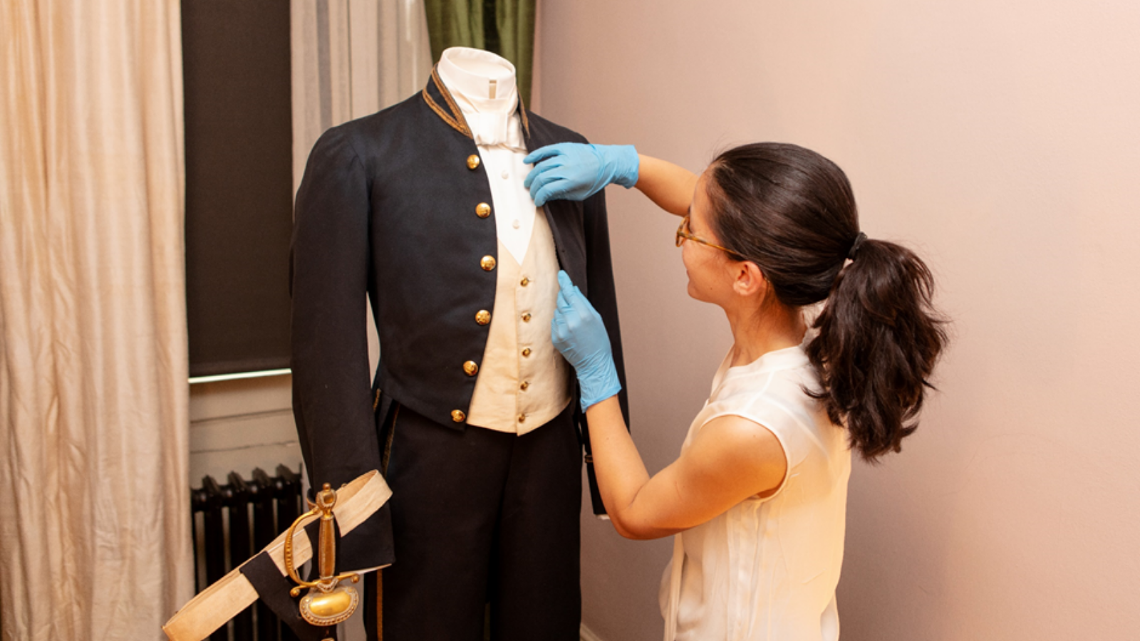 Curator condition checks Dickens's suit